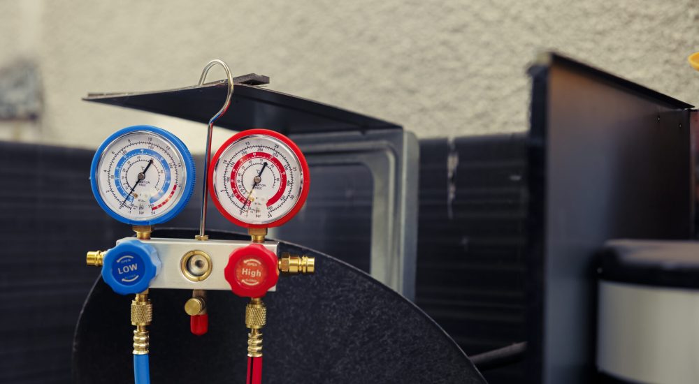 Close up of manifold gauges used for checking air conditioner refrigerant in need of maintenance. Set of barometer high or low freon levels benchmarking hvac system component