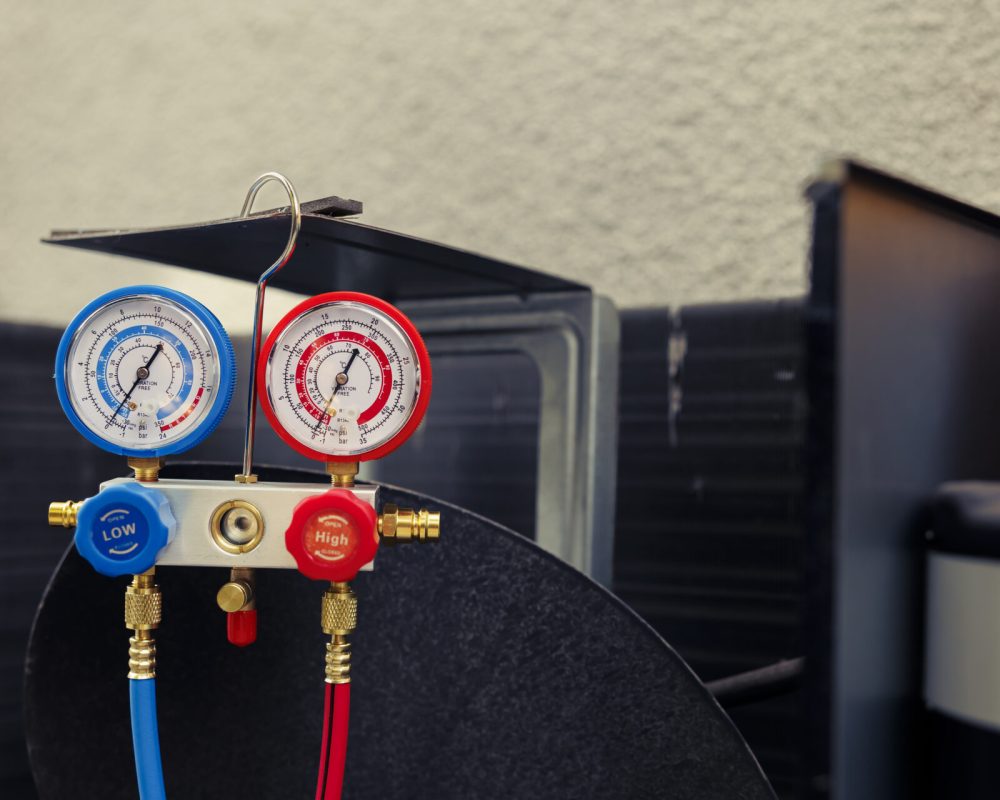 Close up of manifold gauges used for checking air conditioner refrigerant in need of maintenance. Set of barometer high or low freon levels benchmarking hvac system component